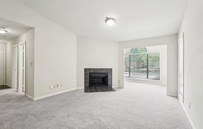 A spacious living room with a fireplace and a sun room