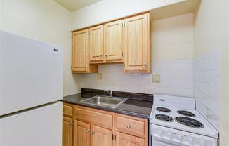 kitchen with gas range, wood cabinetry and energy efficient appliances at alpha house apartments in washington dc