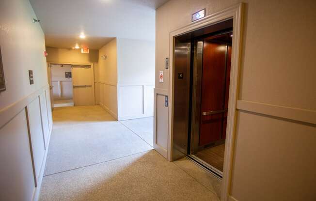 a hallway with a door to a bathroom and a kitchen