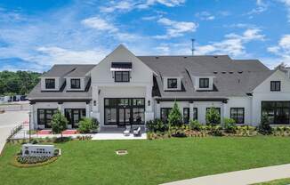 a white house with black shutters and a green lawn