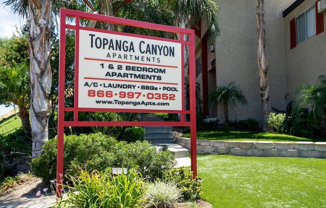 Apartments for Rent in West Hills - Topanga Canyon - Exterior View of Monument Sign with Lush Landscaping and View of Apartment Building