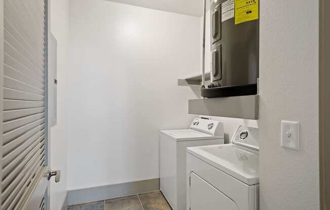 a laundry room with a washer and dryer and a microwave on the wall