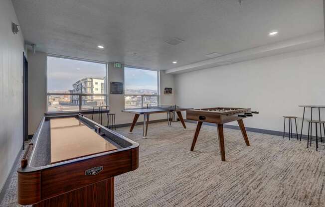 A room with a pool table and a view of the city.