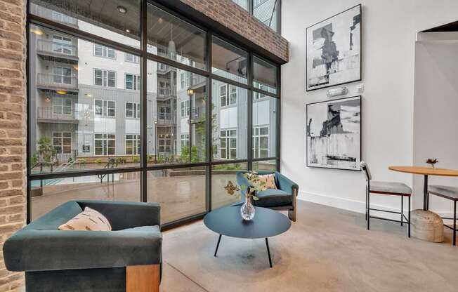 a living room with large windows and a blue coffee table