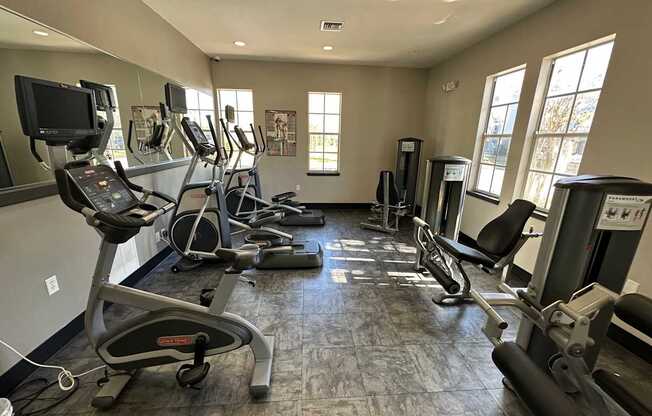 A gym with treadmills, elliptical machines, and other exercise equipment.