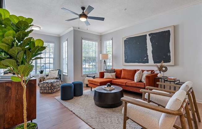 a living room with a orange couch and a ceiling fan