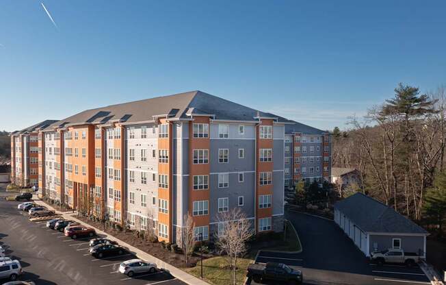 A large apartment building with a parking lot in front.