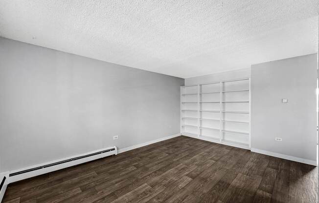 A room with wooden flooring and white walls.