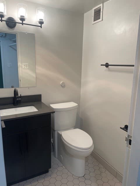 A white toilet sits next to a sink in a bathroom.
