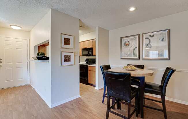 a dining area with a table and chairs and a kitchen