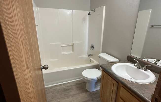 an open door leading into a bathroom with a toilet sink and tub