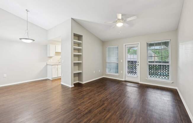 A room with a ceiling fan and a window with blinds.