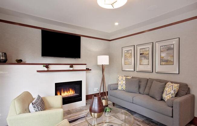 A living room with a fireplace, a couch, a chair, and a television.