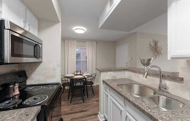 A kitchen with a table and chairs in the middle.