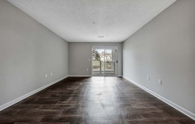 A room with a brown floor and white walls.