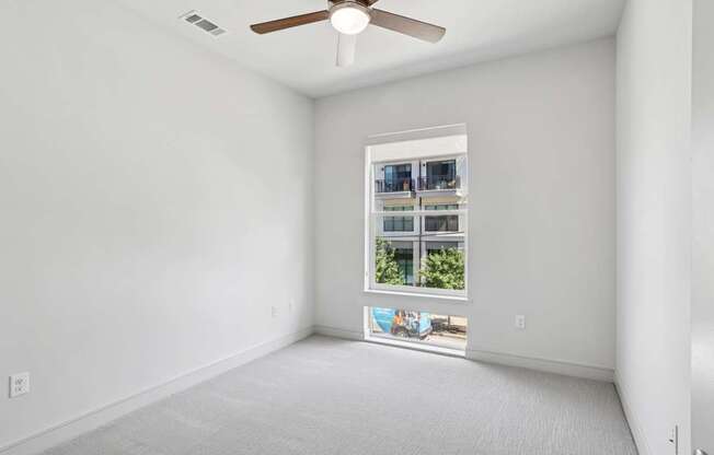 A bedroom with a window and a ceiling fan at Knox Heights Apartments in Dallas, TX