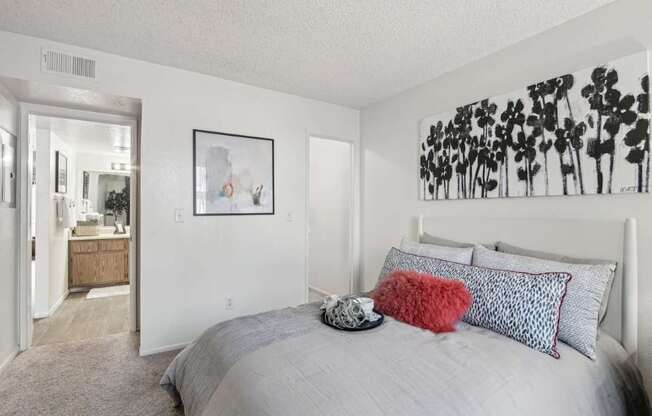 A bedroom with a large bed and a painting on the wall.
