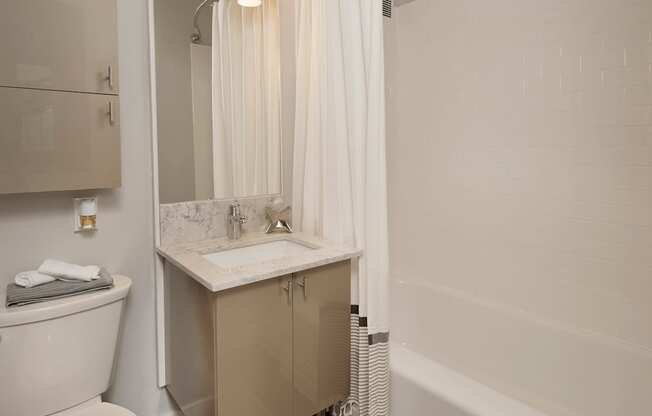 A white toilet sites next to a sink in a bathroom