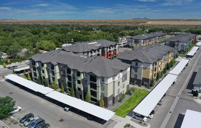 an aerial view of a row of apartment buildings with trees in the background
