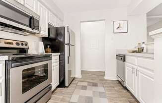 a kitchen with stainless steel appliances and white cabinets