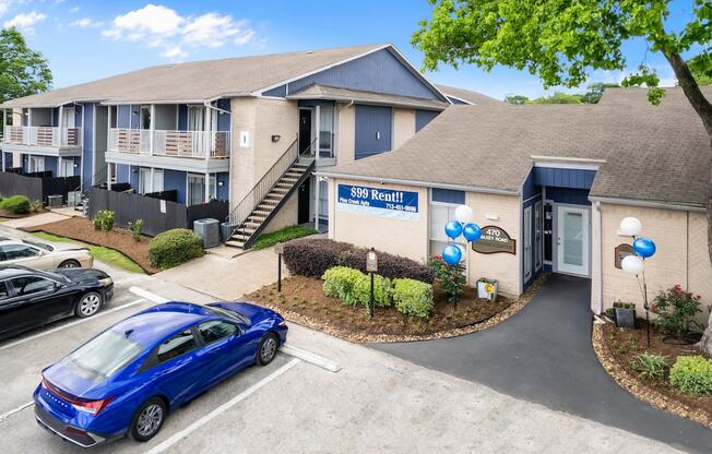 a building with a parking lot and a blue car in front of it