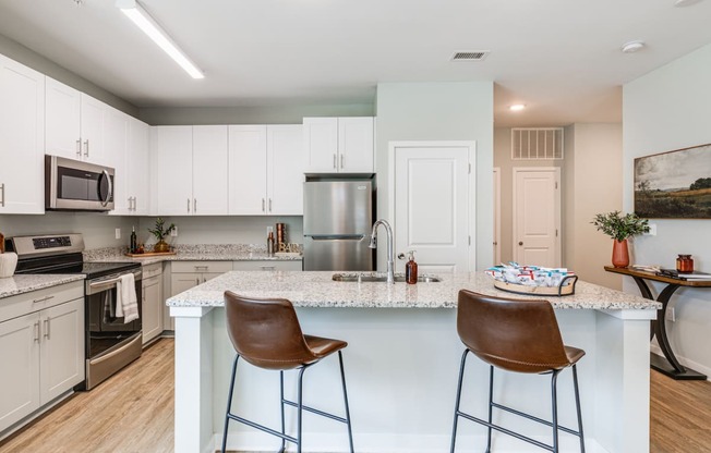 an open kitchen with a large island with two bar stools