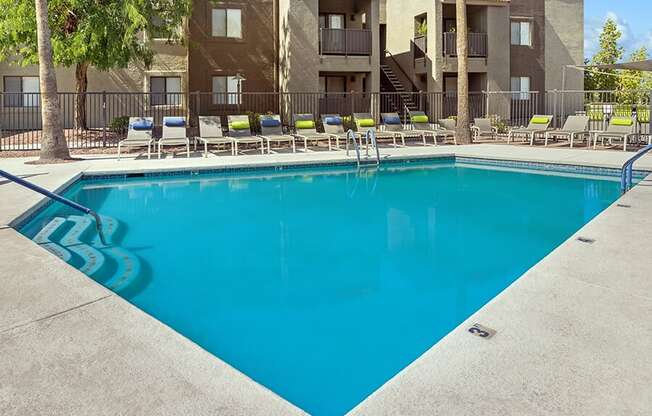 Community Swimming Pool with Pool Furniture at Saddle Ridge Apartments in Tucson, AZ.