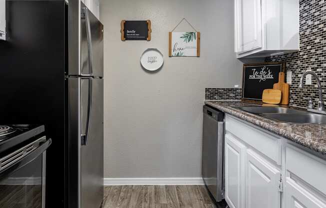 a kitchen with stainless steel appliances and white cabinets