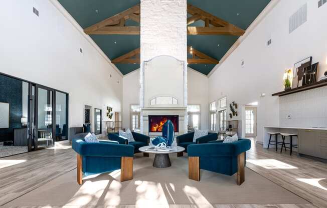 seating area in club house with blue couches and a fireplace