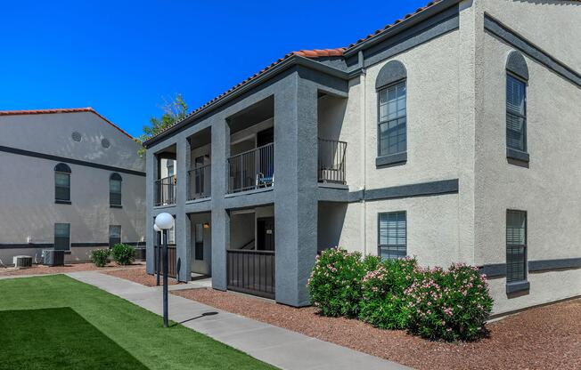 a large brick building with grass in front of a house