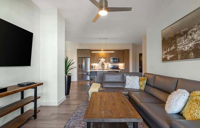 A modern living room with a brown leather couch and a wooden coffee table.