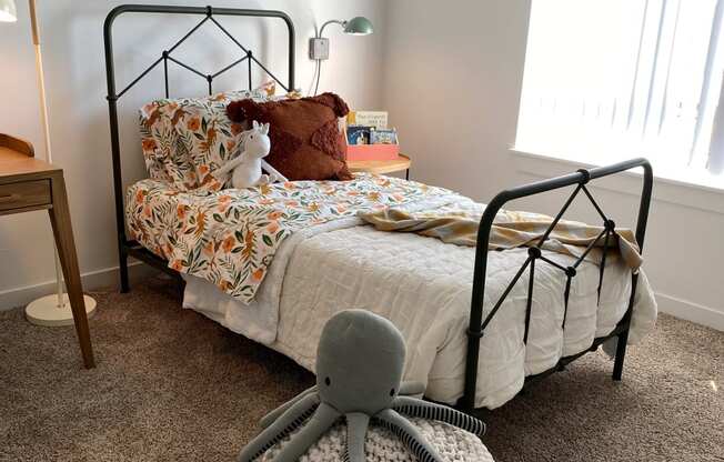 a bedroom with a bed and a rocking chair in front of it