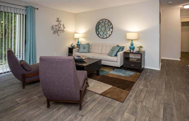 A living room with a purple chair and a white couch.
