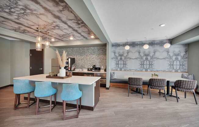 A kitchen with a bar area and blue chairs.