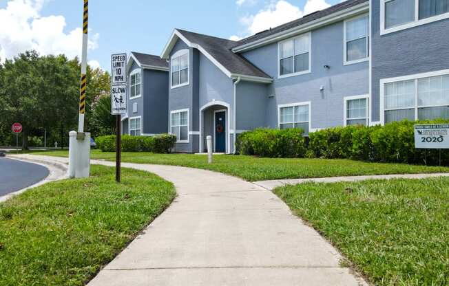 Apartment building exterior surrounded by native landscaping and walkways