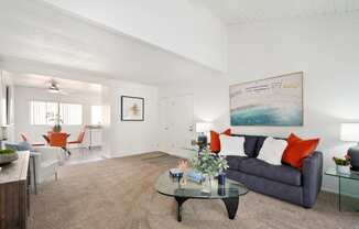 a living room with a blue couch and a glass coffee table