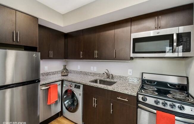 a kitchen with brown cabinets and a white stove top oven