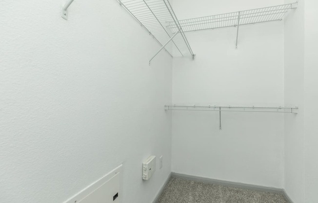 an empty room with white walls and a white urinal in the corner