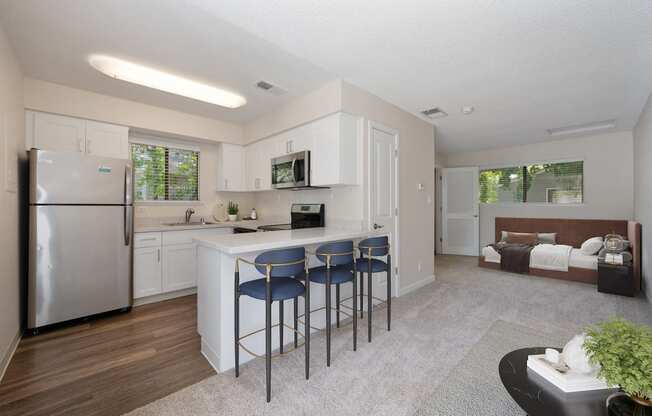 a kitchen with a bar with three stools