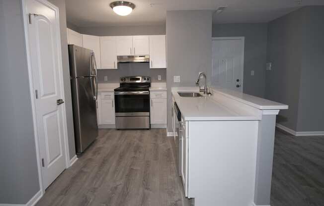 a kitchen with white cabinets and stainless steel appliances at Evergreen Luxury Apartments, Indiana