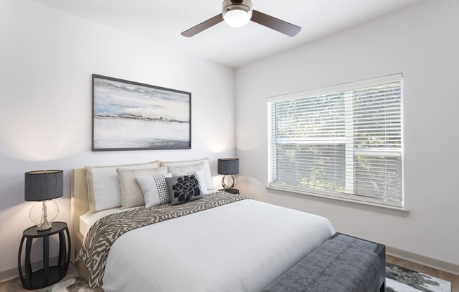 a bedroom with a large bed and a ceiling fan