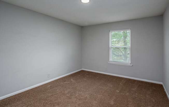 a bedroom with gray walls and a window