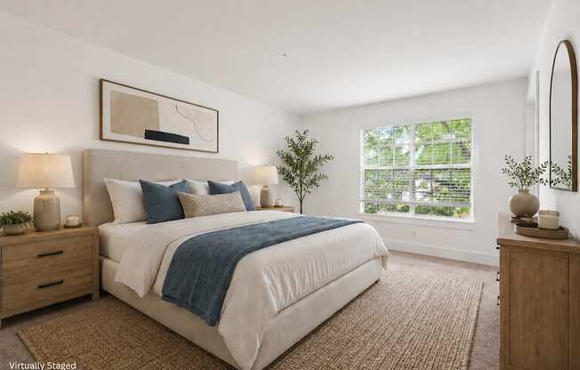 A bedroom with a large bed, a nightstand, and a mirror.