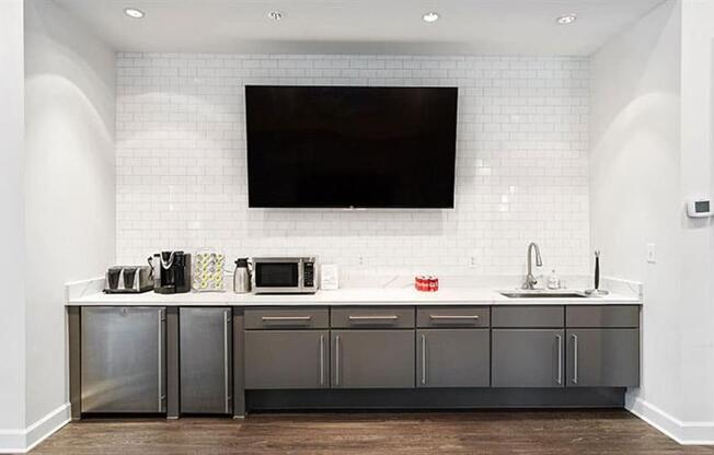 a kitchen with a sink a microwave and a television at Trails at Short Pump Apartments, Richmond, VA