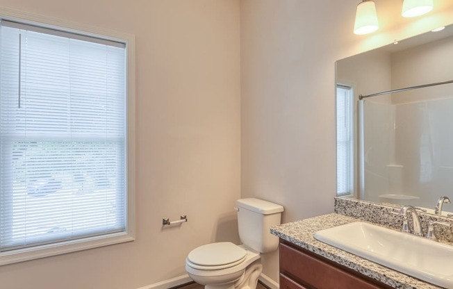 a bathroom with a sink toilet and a large window