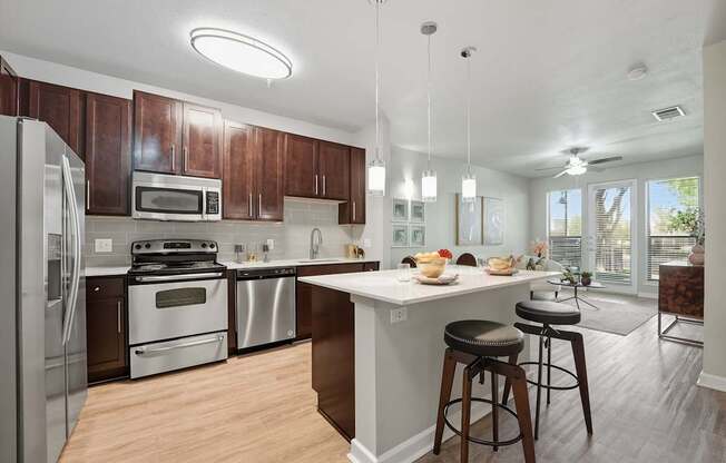 A modern kitchen with wooden cabinets and stainless steel appliances.