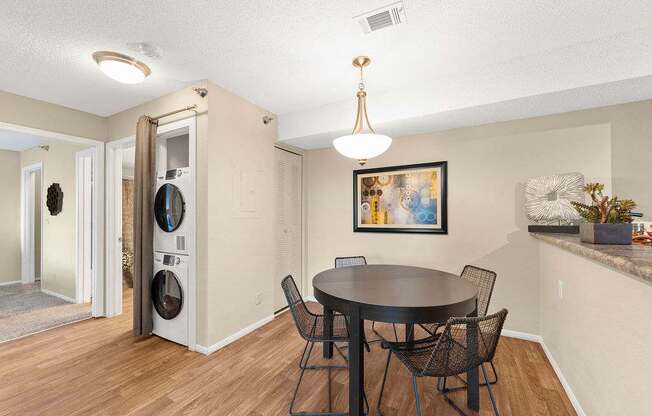 A dining room with a round table and chairs.