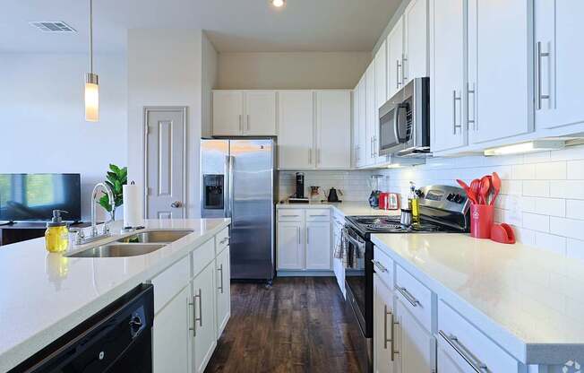 A kitchen with white cabinets and a black dishwasher.