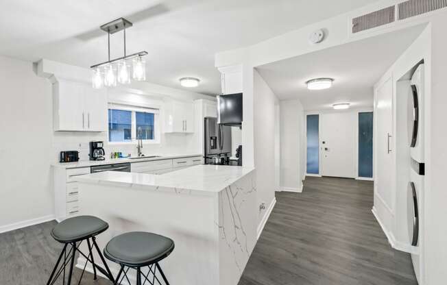 a kitchen with a bar and stools in a house