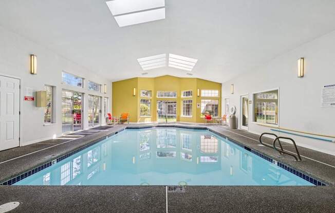 A large indoor swimming pool with a tiled floor.